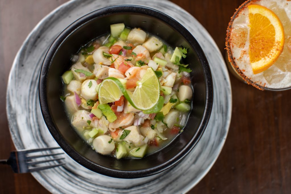 Ceviche with Mexican bay scallops, white shrimp, mahi-mahi, cucumber, avocado, tomato, red onion, lime, cilantro and crispy corn tortillas.